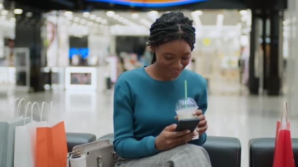 Afrikai Amerikai Sms Ezés Okostelefonon Koktél Ivás Miközben Pihen Kanapén — Stock videók