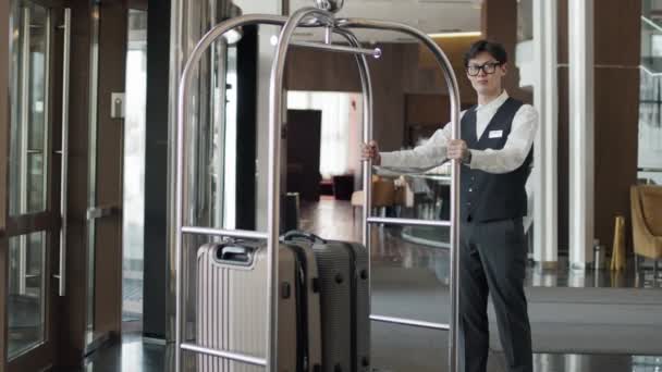 Retrato Joven Portero Hotel Asiático Moderno Pie Con Carrito Equipaje — Vídeos de Stock