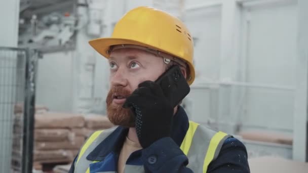 在大理石工厂工作的身穿制服和硬礼帽的白人男子在电话交谈中的特写镜头 — 图库视频影像
