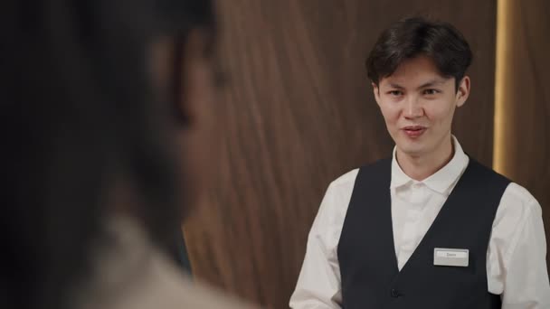 Yeni Otel Müşterisiyle Çalışan Genç Asyalı Resepsiyonistin Omzunun Üstünden Seçici — Stok video