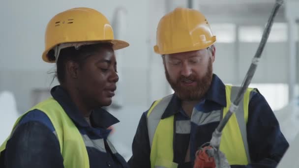 Vit Man Som Arbetar Fabrik Visar Afroamerikansk Kvinnlig Anställd Hur — Stockvideo