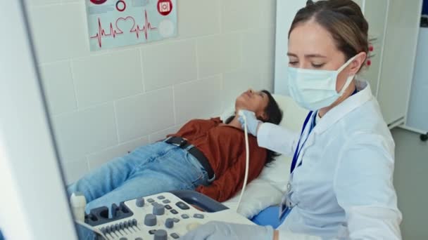 Жінка Медик Захисній Масці Рукавичках Робить Медичне Ультразвукове Сканування Молодого — стокове відео