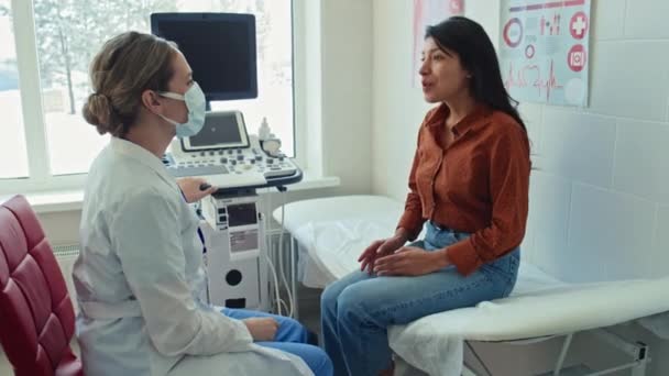 年轻快乐的西班牙裔女性患者坐在超声专家面前 感谢她 并握手 — 图库视频影像