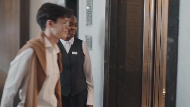非洲裔美国妇女搬运工或门房慢吞吞地把客人送进电梯 — 图库视频影像