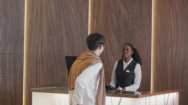 Młoda Afroamerykanka Pracująca Recepcji Daje Gościom Hotelowym Karty Magnetyczne — Wideo stockowe