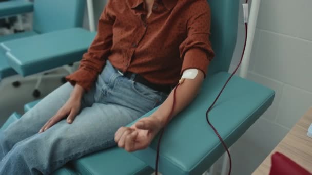 血液抽出プロセス 献血コンセプトのために彼女の手をひねる認識できない女性の高角度ビュー — ストック動画