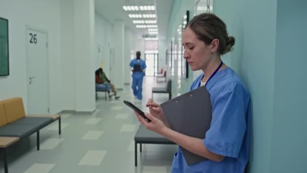 成熟的白人医生站在走廊里选择性地聚焦在智能手机上发短信 — 图库视频影像