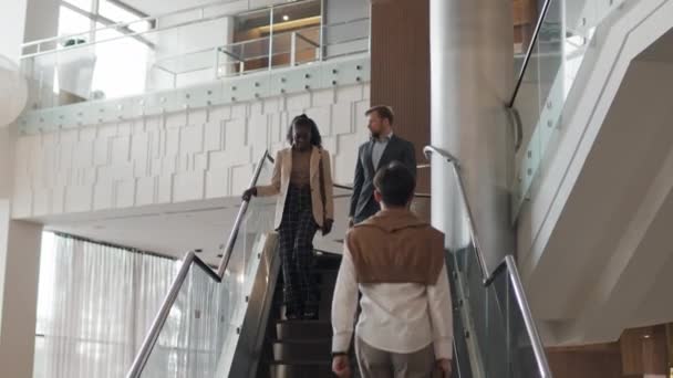 低い角度のコーカサス人男性と黒人女性が階下を歩いている間にビジネスプロジェクトを議論 — ストック動画
