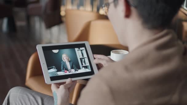 年轻人在商务旅行中的一个有选择的焦点是与同事一起坐在咖啡桌旁 用数字平板电脑进行视频通话 — 图库视频影像