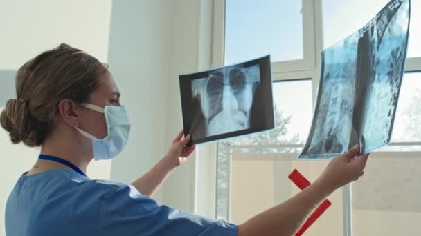 Szakmai Radiológus Maszkot Visel Olvasás Betegek Röntgen Képeket Kórházban — Stock videók