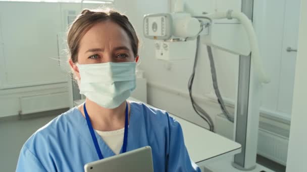 Medium Närbild Porträtt Kvinnlig Radiolog Bär Skyddsmask Håller Digital Tablett — Stockvideo