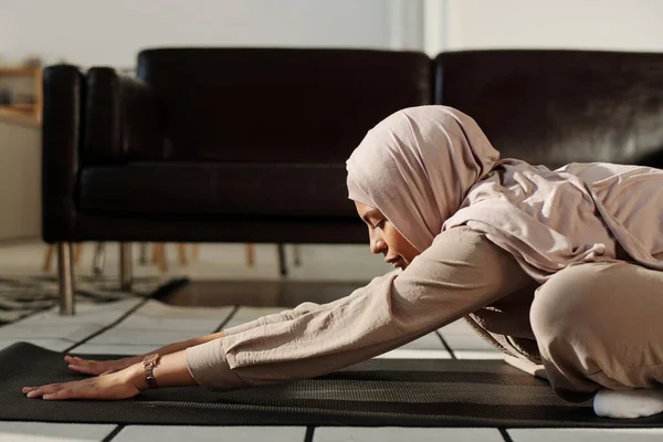 Vista Lateral Jovem Muçulmana Esticando Braços Para Frente Enquanto Sentada — Fotografia de Stock