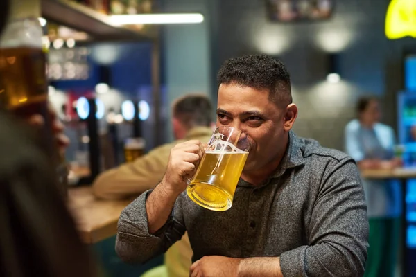 Młody Mężczyzna Szarej Koszuli Pijący Orzeźwiające Piwo Kubka Siedząc Barze — Zdjęcie stockowe