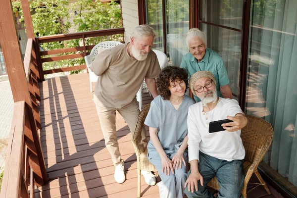 Pessoas Idosas Felizes Seu Cuidador Levando Selfie Pátio Casa Repouso — Fotografia de Stock