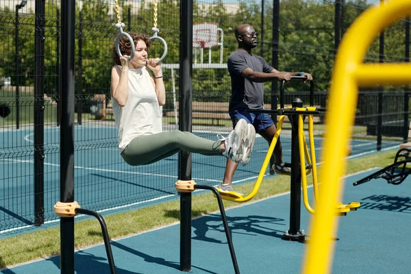Young Brunette Sportswoman Hanging Still Rings Doing Sits Sports Ground — Stock Photo, Image
