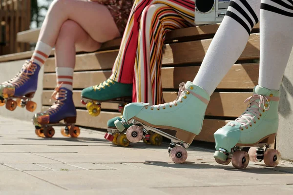 Nogi Trzech Dziewcząt Rolkach Ubraniach Casualwear Siedzących Ławce Parku Słoneczny — Zdjęcie stockowe
