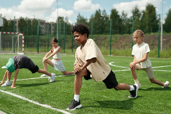 Grupo Crianças Idade Escolar Fazendo Exercício Físico Grama Verde Campo — Fotografia de Stock