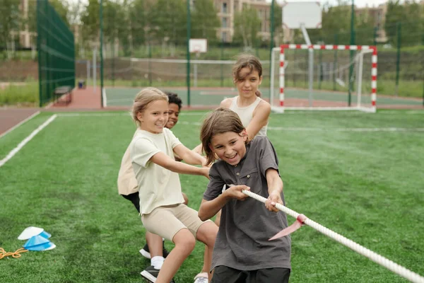 スタジアムでより強力なチームと学校スポーツ競技中にロープを引っ張りながら 強力でアクティブな子供たちのグループ — ストック写真