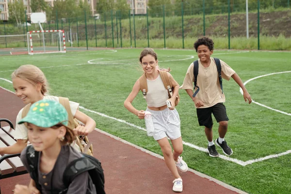 Group Cheerful Intercultural Schoolkids Backpacks Running Out Stadium Sports Ground — Stock Photo, Image