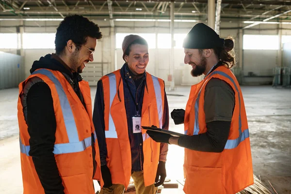 Tres Jóvenes Trabajadores Masculinos Felices Almacén Discutiendo Puntos Presentación Mientras —  Fotos de Stock