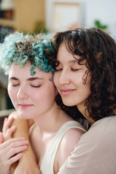 Mutlu, genç, sevecen, siyah dalgalı saçlı bir kadın. Sakin kız arkadaşına sarılıyor ve birlikte olmaktan zevk alıyor.