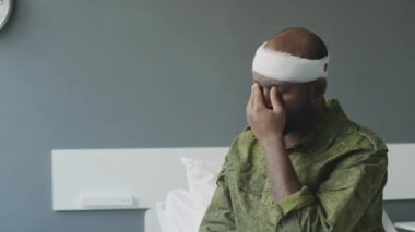 Kafasından yaralanmış Afro-Amerikan askerinin hastane odasında gözlerini ovuşturup gözlerini kaçırdığı görüntüler.