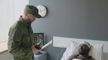 Kafkasyalı yüzbaşı Afrikalı Amerikan askerini askeri hastanede ziyaret ederek ödülden dolayı onu tebrik etti.