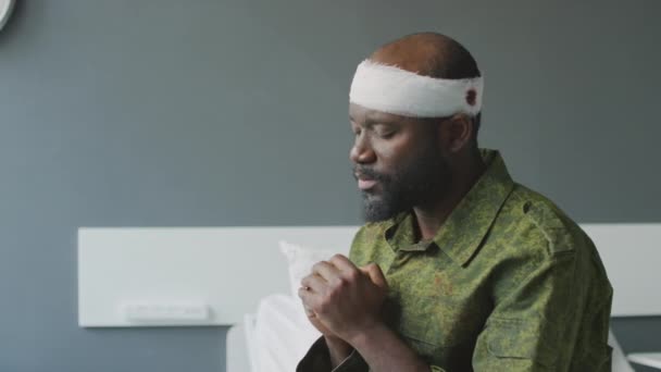 Közepes Közelkép Fekete Katona Fejsérüléssel Kórházi Szobában Csukott Szemmel Imádkozva — Stock videók