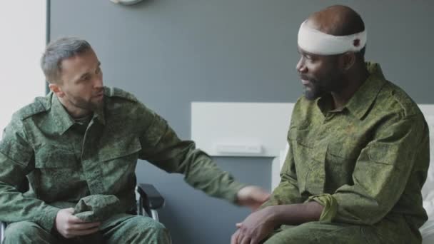 軍病院の部屋に座っている民族的に多様な兵士のスローモーションショットは 戦闘後に生き残ったお互いを喜んで見ます — ストック動画