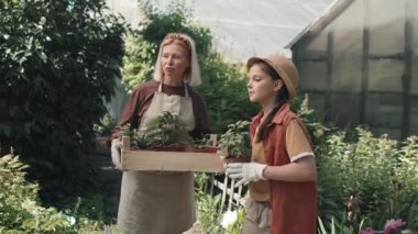 Büyük Kafkasyalı büyükanne ve torunu güneşli bir yaz gününü bahçede çiçek ekecekleri yeri tartışarak geçiriyorlar.
