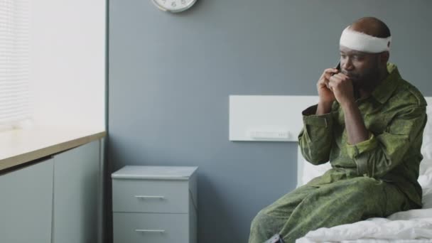 Чорний Військовослужбовець Травмою Голови Сидить Ліжку Військовій Лікарні Розмовляє Телефону — стокове відео