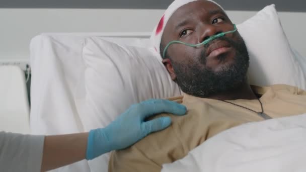 軍病院で頭部負傷したアフリカ系アメリカ人兵士を慰める認知できない医療従事者 — ストック動画