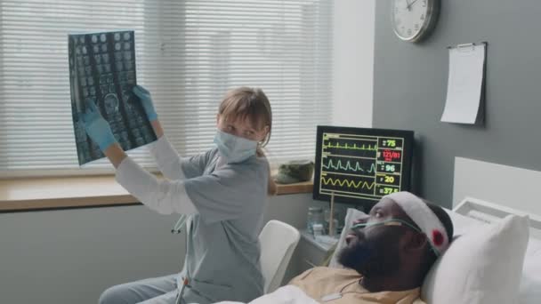 Kvinnlig Läkare Som Håller Röntgenbild Förklara Något För Sin Patient — Stockvideo