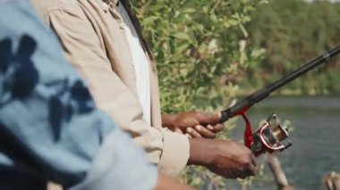 Afrika kökenli Amerikalı son sınıf öğrencisinin torununa olta kullanarak balık tutmayı öğretirken seçici bir odak noktası.