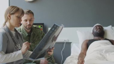 Askeri hastanede çalışan bir cerrah. Röntgen görüntüsü tutuyor. Hastaların sağlık durumunu arkadaşına anlatıyor.