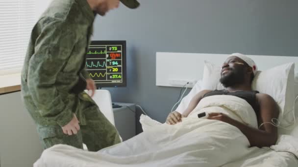 Wesoły Biały Żołnierz Odwiedza Swojego Czarnego Przyjaciela Szpitalu Wojskowym Witając — Wideo stockowe