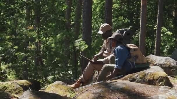 Активный Афро Американский Дедушка Внук Сидят Скале Горном Лесу Читая — стоковое видео