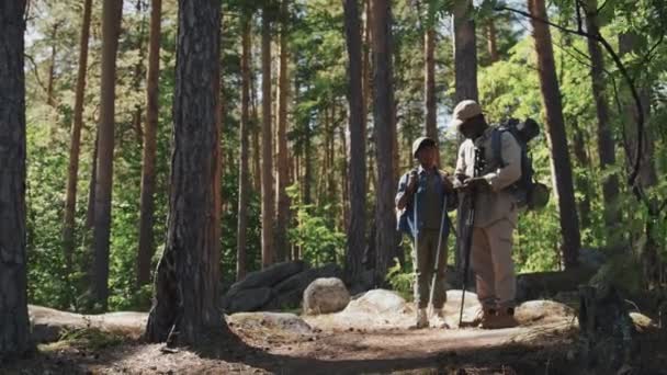 年富力强的老人和孙子在山林里徒步旅行 用指南针指明方向 — 图库视频影像
