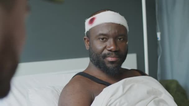 受伤的黑人军人坐在病床上与他最好的朋友交谈的选择性焦点镜头 — 图库视频影像