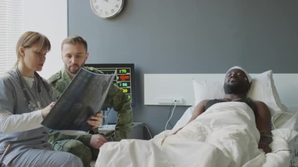 Doktor Pracující Vojenské Nemocnici Ukazující Rentgenový Snímek Pacientů Míří Svému — Stock video