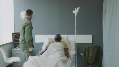 Bilinci yerinde olmayan arkadaşının kritik durumuna tanık olan bir asker, doktoru kurtarması için çağırıyor.