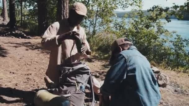 非裔美国人的祖父和孙子在湖边扎营 从背包里取出东西 — 图库视频影像