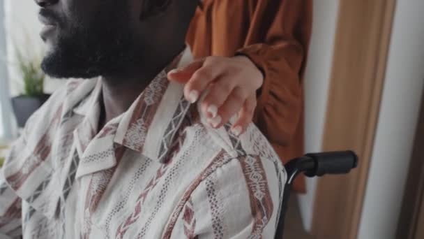 彼の肩に車椅子で黒人男性をパットするコーカサス人女性のクロップショット 彼の手に触れる — ストック動画