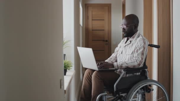 Orta Boy Tekerlekli Sandalyede Gözlüklü Koridorda Oturmuş Dizüstü Bilgisayarda Yazarken — Stok video