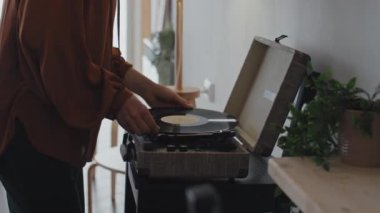 Kırmızı bakır bluzlu genç beyaz kadın pikaba geliyor, onu açıyor ve gündüzleri yavaşça dans etmeye başlıyor.