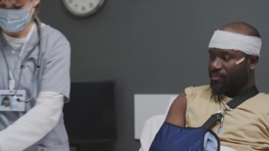 Kolu kırık ve başından yaralanmış bir Afrikalı Amerikan askerinin orta boy fotoğrafı. Omzundan iğne olmuş.