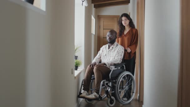 Tiro Completo Homem Negro Cadeira Rodas Assistida Pela Jovem Mulher — Vídeo de Stock