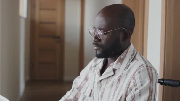 Medelhög Bild Afroamerikansk Man Rullstol Bär Glasögon Sitter Korridoren Skriva — Stockvideo