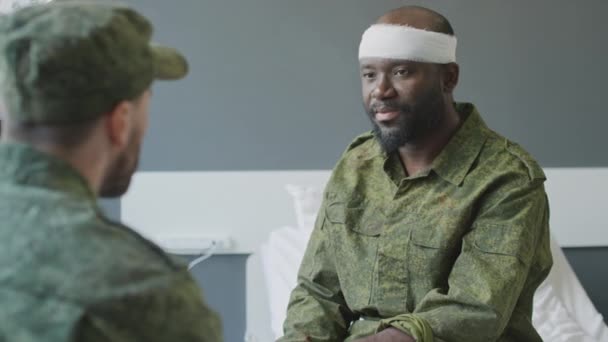 非洲裔美籍上尉头部受伤躺在病床上与访客聊天的选择性聚焦镜头 — 图库视频影像