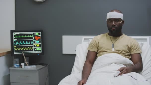 現代の病院で治療を受けている頭部に負傷したアフリカ系アメリカ人軍人の中型肖像画 — ストック動画